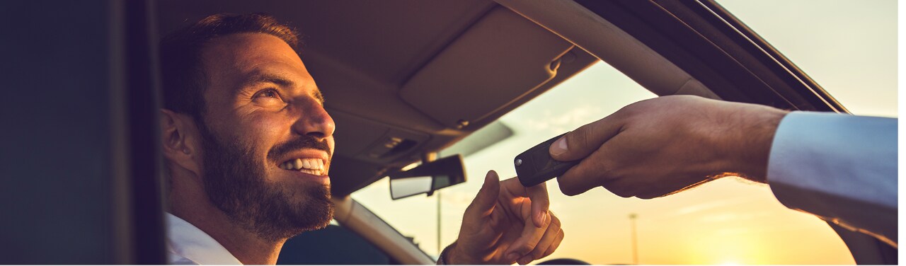 Un client quitte une agence Enterprise Rent-A-Car à bord d’un VE de location.
