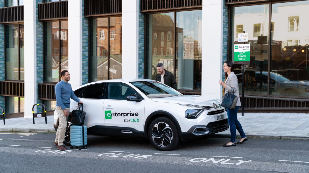 3 Personen steigen in ein Fahrzeug des Enterprise Car Club ein.