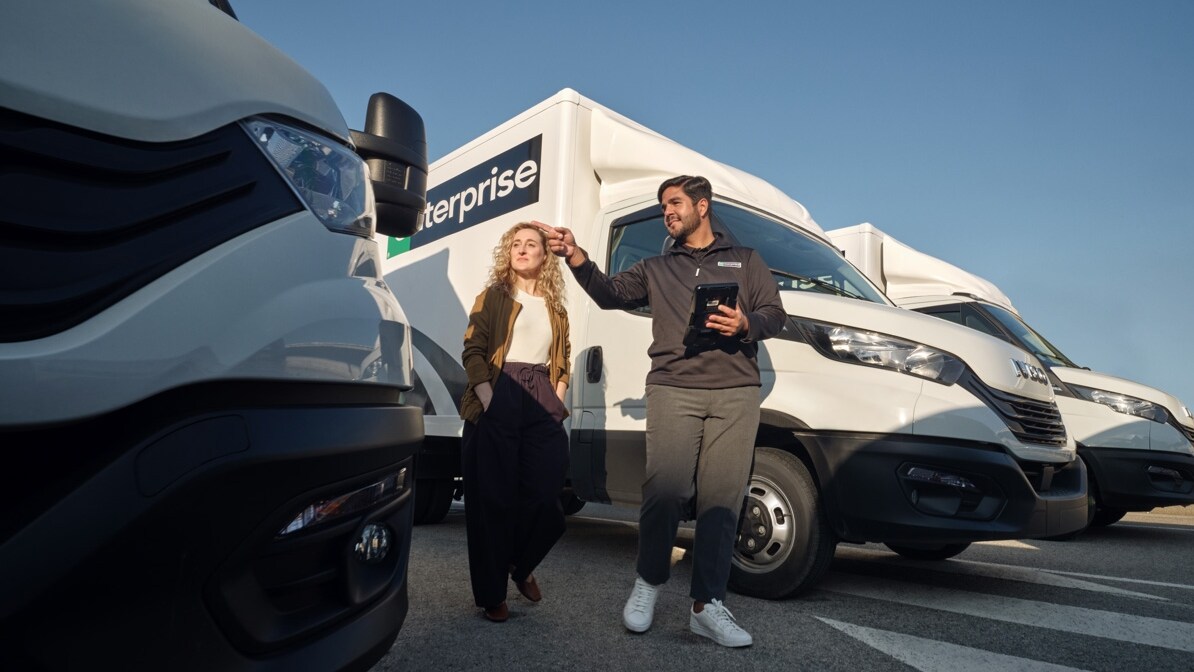 Salesman and woman customer looking at Enterprise trucks